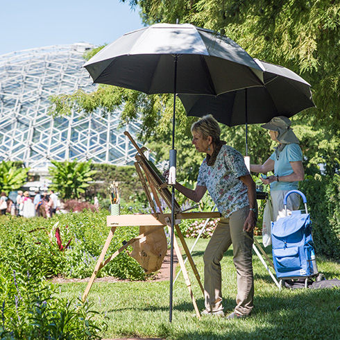 Visitor painting outdoors with Climatron conservatory in background