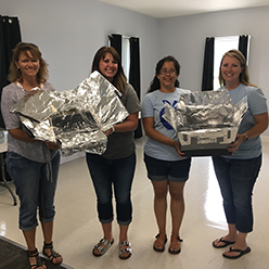 Educators holding solar ovens